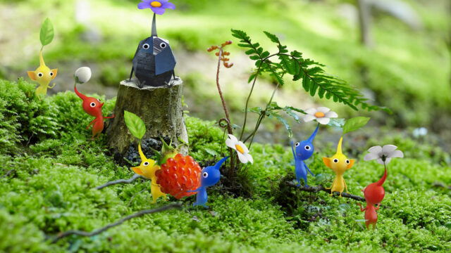 Two Pikmin carrying a raspberry surrounded by others there to help.